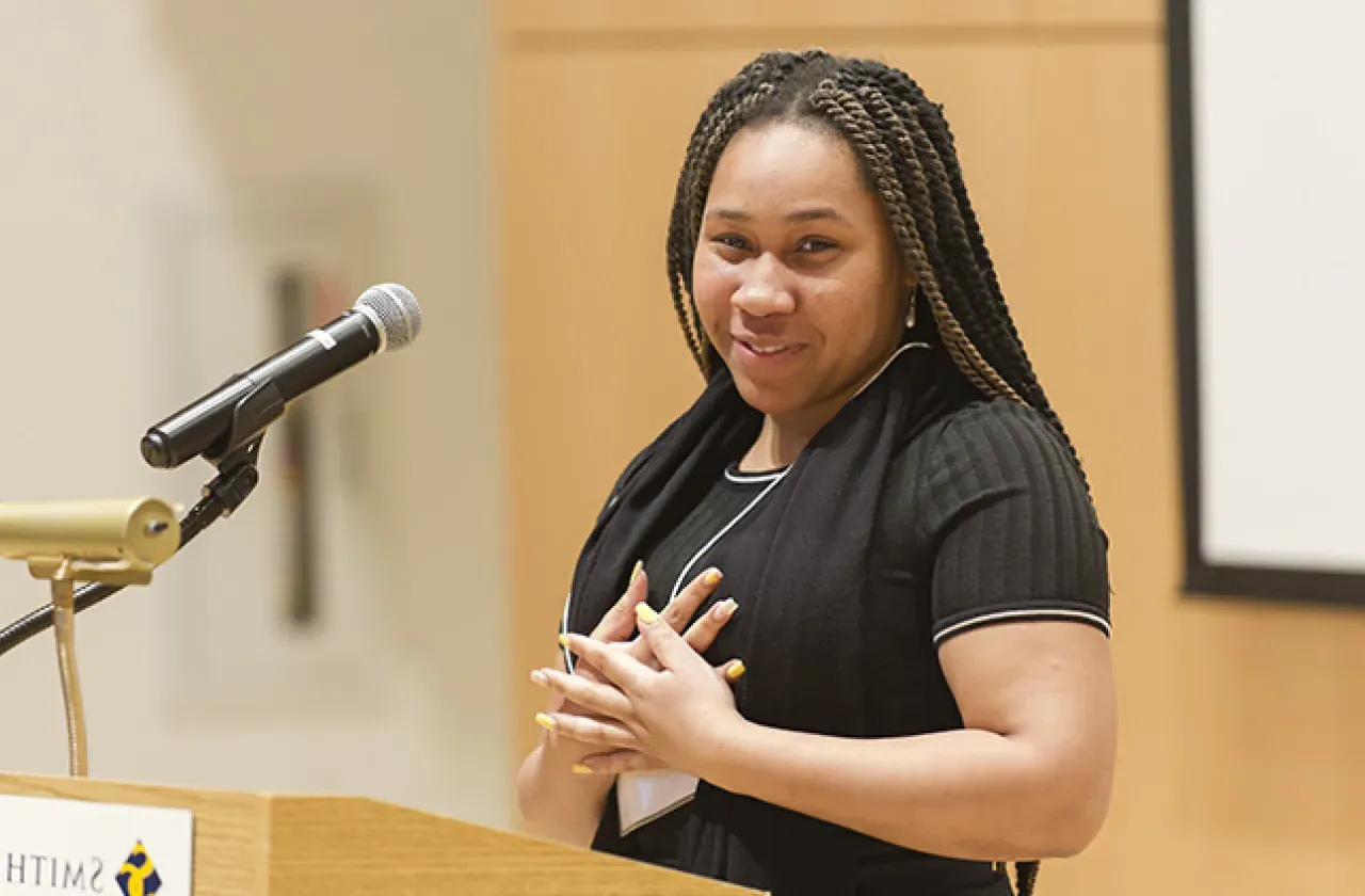 Student smiling at a podium